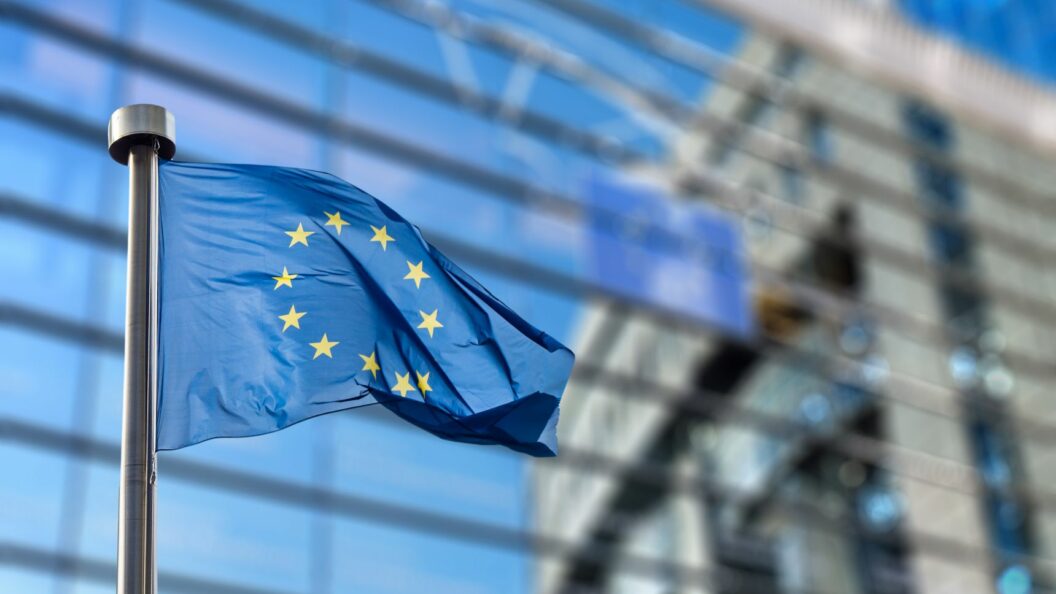 Europäische Union Flagge vor Gebäude – Symbol für das EU Entry/Exit System (EES)